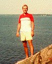 A photo of Alex Stuy standing on the beach at Lake Champlain